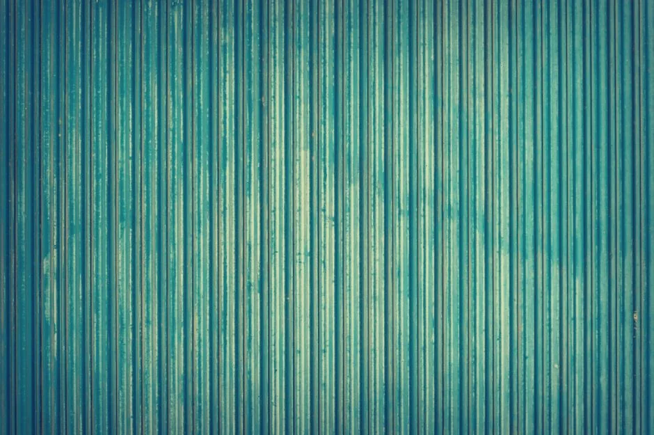 Vue plongeante d’une équipe en entreprise travaillant ensemble autour d’ordinateurs portables et de documents.